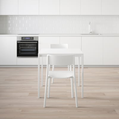 Minimalistisk köksinredning med stapelbara MELLTORP-stolar, robust metallbord och inbyggd ugn.