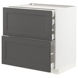 Ett vitt METOD köksskåp med mörkgrå lådor. Den har två stora lådor med klassisk design, placerade mot en vit ram. Robust och modern.