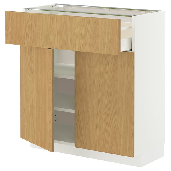 En vit köksmöbel från METOD med lådor och hyllor i ljust trä, med modern design och ett elegant och rent utseende.