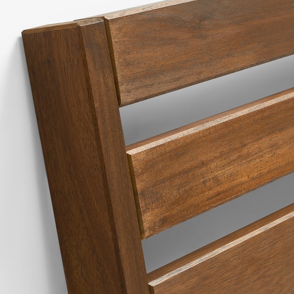 Detalj av träutklädda utemöbler. Slät, polerad finish av akaciaträ med jämn betsning, vilket framhäver kvalitetshantverk och hållbar design.