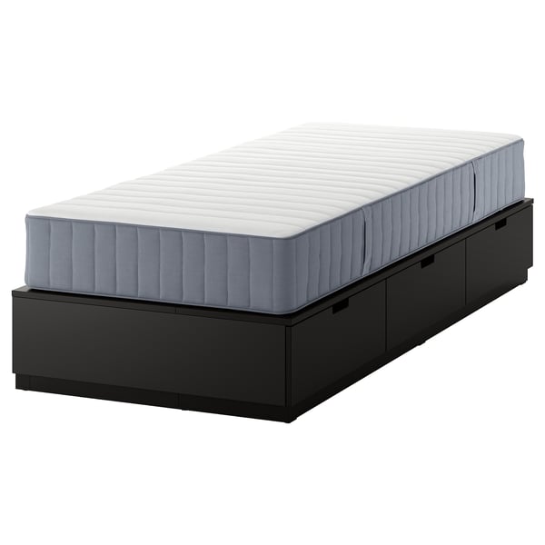 En svart NORDLI sängstomme med tre lådor och en vit madrass. Det är en platsbesparande lösning med inbyggd förvaring.