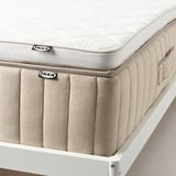 Ikeas nylåget bäddmadrass på stativ. Visar latex- och tygdesign, reglering av temperatur och stödkomfort.