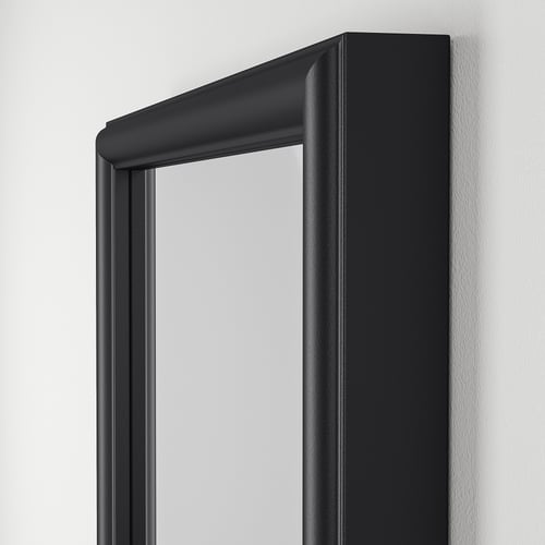 Svart inramad spegel på vit vägg; Visar kvalitet och designdetaljer.