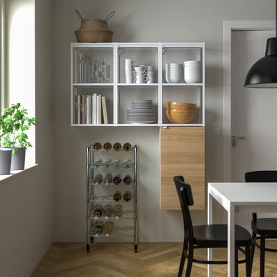 Modern kökshörna med OMAR-hylla, keramik, kokböcker, vinställ, matbord, stolar, trägolv.