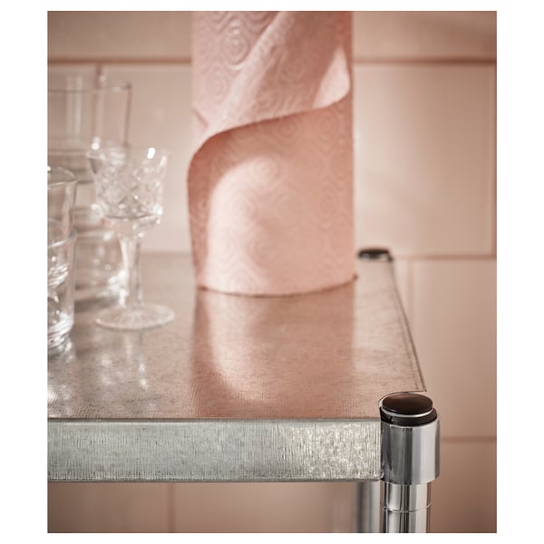 En silverfärgad metallhylla med cylindriskt stöd. Dess eleganta design gör den lämplig för olika inomhusutrymmen.