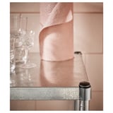 En silverfärgad metallhylla med cylindriskt stöd. Dess eleganta design gör den lämplig för olika inomhusutrymmen.