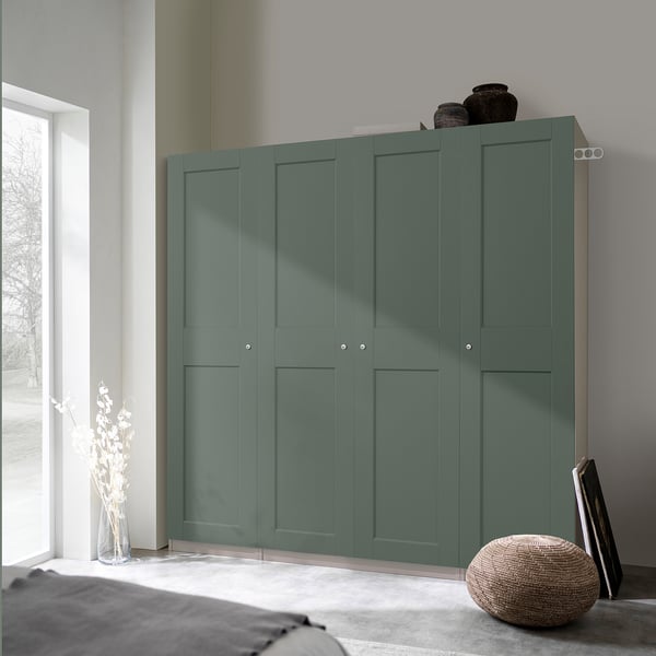 Teal PAX garderob bredvid fönster i minimalistiskt sovrum med förvaring och inredning.