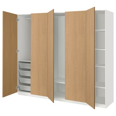 En öppen ekfärgad ikea PAX garderob med hyllor och lådor.