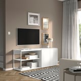 Modernt vardagsrum med vit PLATSA förvaringsenhet, tv, foton, inredning, på randig matta nära fönstret.