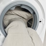 Tvättmaskinstrumma med laddat ljust tyg.