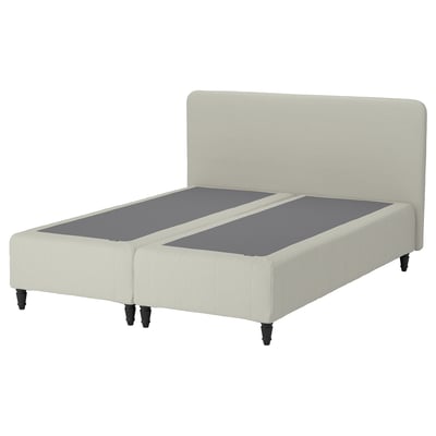 En sängstomme från renfjället i beige med huvudgavel och en grå madrass. Designen är modern och stoppad, vilket ger komfort och stil.