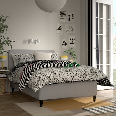 Modernt sovrum med sängen RISEHÖJDEN , grå sänggavel, blandade sängkläder, abstrakt konst, dubbelsäng, sidobord med växter och böcker.