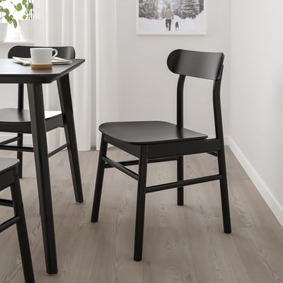 Modern svart trästol, elegant och enkel design, passar snyggt under bordet, perfekt för små utrymmen.