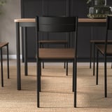 Modern stol med svarta metallben och träsits. Designad för komfort och små utrymmen.