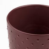 Cylindrisk vinröd planteringslåda med jämnt fördelade gropar, slät finish.