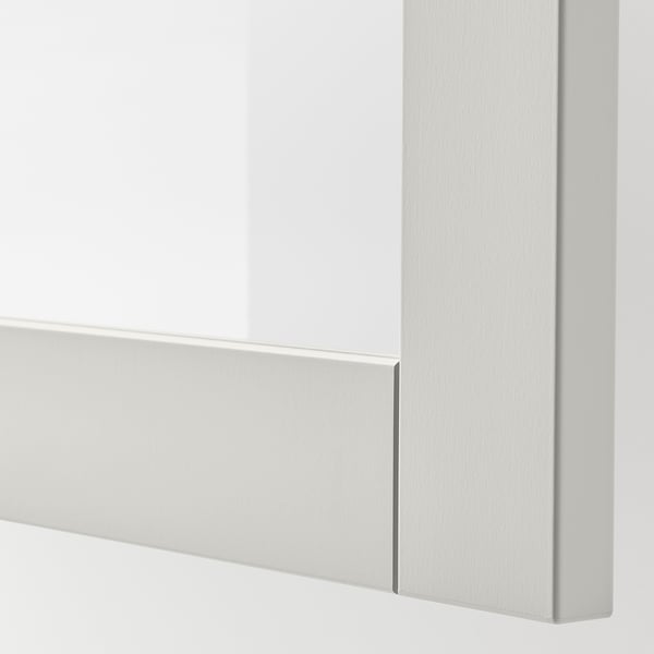 Närbild av SINDVIK ljusgrå skåp med front i klarglas, som visar upp elegant och modern design.