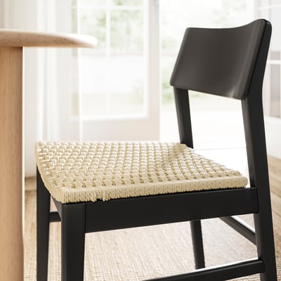 Modern svart skandinavisk stol med vävd sits, snygg och bekväm.