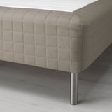 Modern, stoppad säng med eleganta metallben som visar upp högkvalitativt hantverk och komfort.