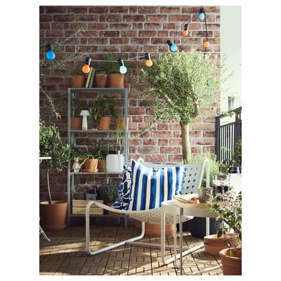 En ljusgrå stol SKOGSÖN med sits och rygg i perforerad stål, rundade former och ben i metall.