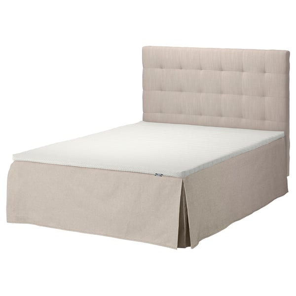 En beige säng SKOTTERUD med en tuftad sänggavel och en matchande gardinkappa. Designen är modern och minimalistisk, perfekt för ett mysigt, neutralt sovrum.