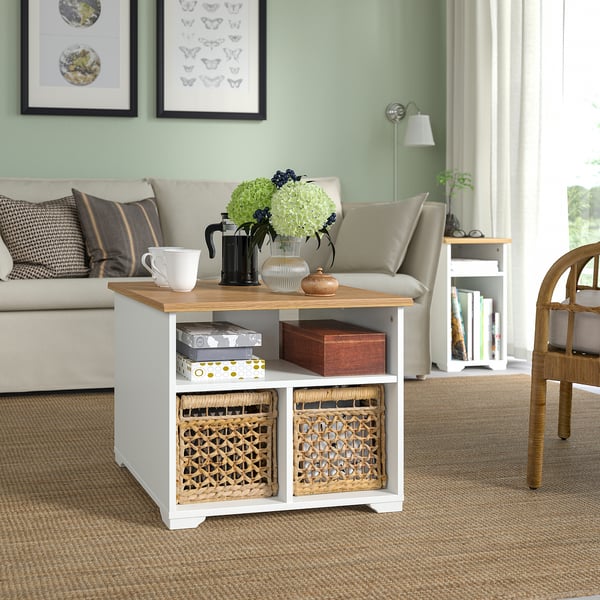SKRUVBY soffbord: vit skiva i trä, korgar och hyllor. Beige soffa, korgstol, grön vägg.