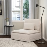 En ljusbeige SÖDERHAMN stol med en modern svart lampa och sidobord på en vit matta.