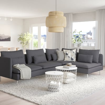 Modernt vardagsrum med stor grå sektionssoffa SÖDERHAMN, vitt soffbord och unik pendellampa.