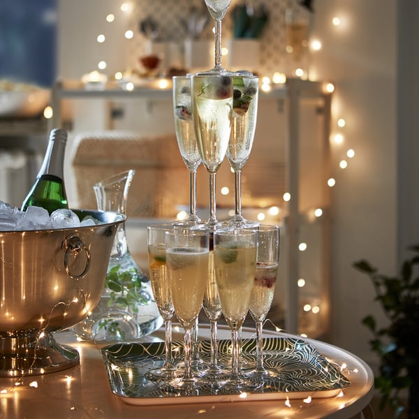 Champagnetorn med glas, flaska i isfylld SOLDRÄNKT-skål, ljus.