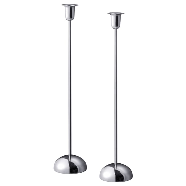 Två eleganta silverljusstakar med cirkulära baser, minimalistisk design, perfekt för bord eller fönster.