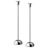 Två eleganta silverljusstakar med cirkulära baser, minimalistisk design, perfekt för bord eller fönster.