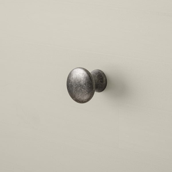 Stor, robust byrå i trä med en strukturerad yta, med runda metallknoppar för hållbarhet och stil.