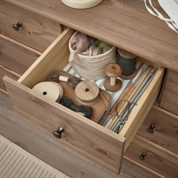 Öppen trälåda med pysselmaterial, inklusive garn, och stickor. Ingår i STOREMOLLA kista.