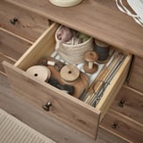 Öppen trälåda med pysselmaterial, inklusive garn, och stickor. Ingår i STOREMOLLA kista.