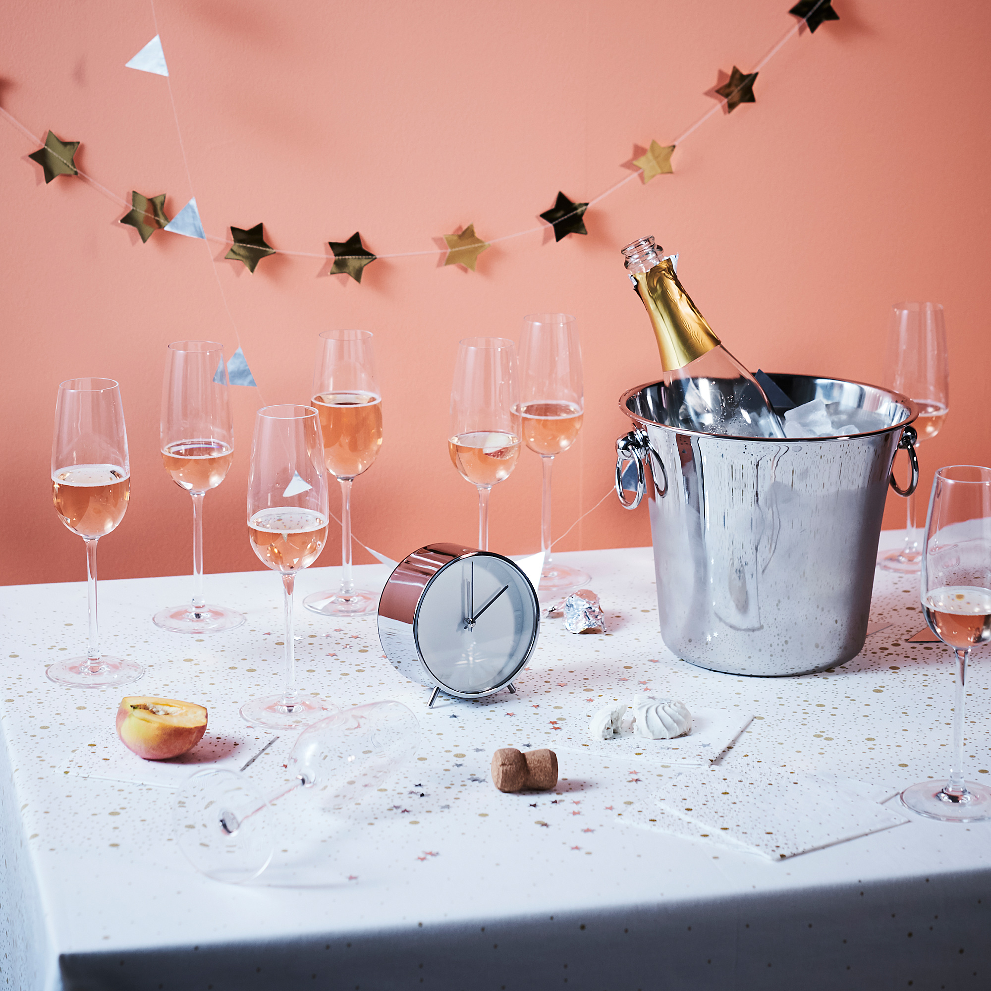 Champagneglas och ishink på bordet, dekorerade med stjärngirlang.