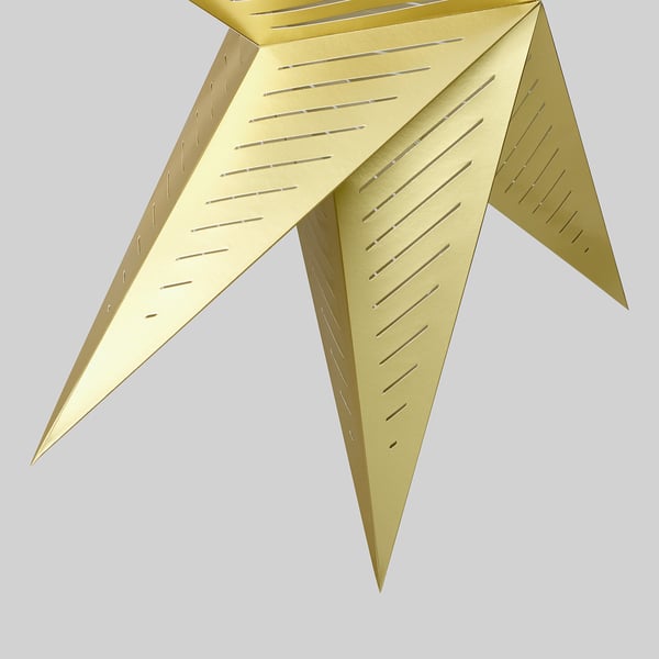 Gyllene geometrisk lampskärm med intrikata perforeringar, avger varmt ljus, stilfullt designad.