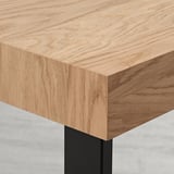 Modernt utdragbart matbord med elegant skiva i ekfanér och robust metallunderrede som visar upp kvalitetshantverk.