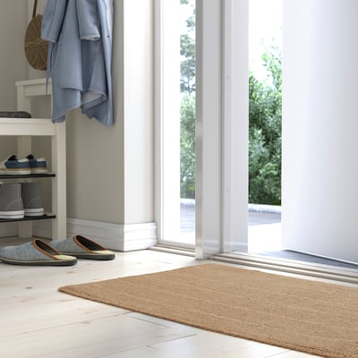 Dörrmatta av jute med ränder och flätade kanter.