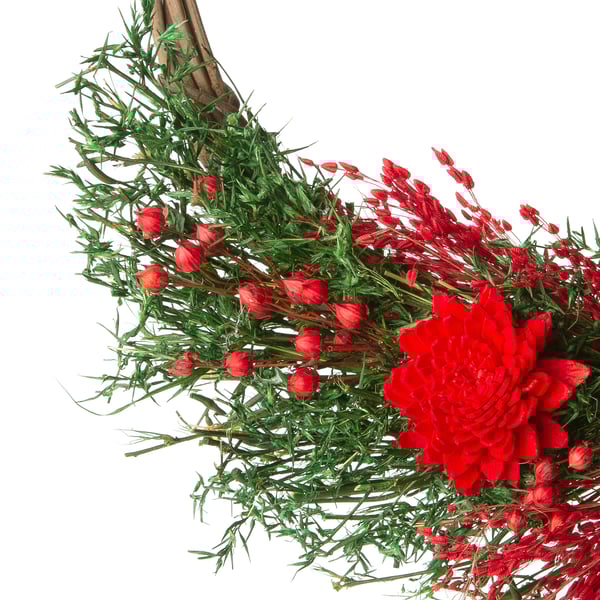 Livfulla röda blommor och grön bladkrans. Den är tillverkad av torkade växtdelar, den är konstfullt anordnad och säkert knuten med ett juterep.