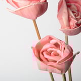Tre delikata rosa rosor arrangerade, fint utformade och detaljerade.