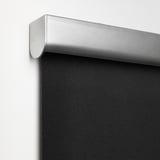 Närbild av en modern mörkläggningsgardin som visar upp det eleganta silverhöljet och den mjukstängande funktionen.