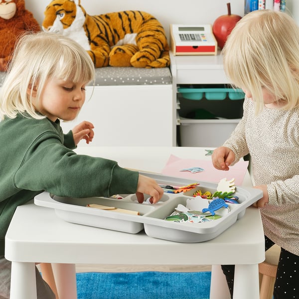 Barn leker med leksaker på TROFAST förvaring och organiserar föremål i fack.