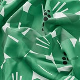 Ljusgrönt bomullstyg med djärva, vita abstrakta bladmönster, skrynkliga för att visa struktur; Perfekt för sömnadsprojekt.