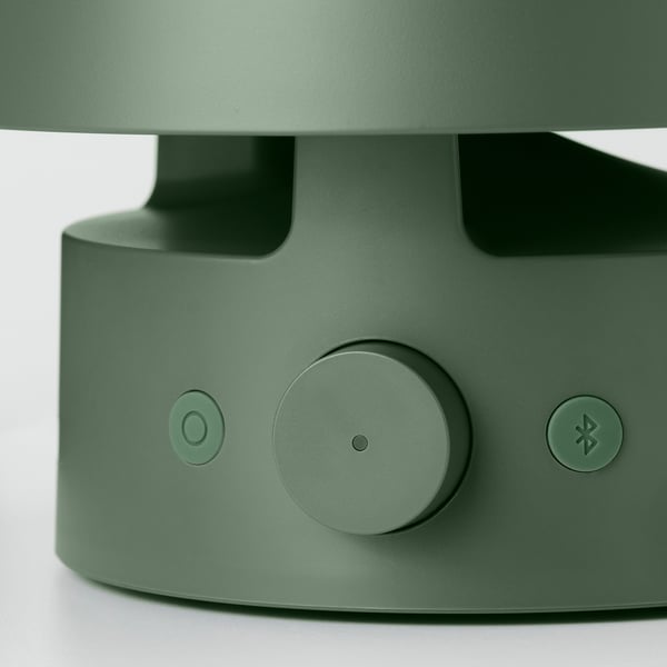 En elegant grön utomhushögtalare med kontroller och ett handtag, som betonar dess förstklassiga design och funktionalitet.
