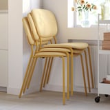 Staplade beige stoppade stolar med guldben i rummet, som visar komfort och stil. Smälter bra in i modern inredning.