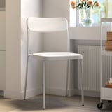 Modern vit plast/metallstol nära fönstret.