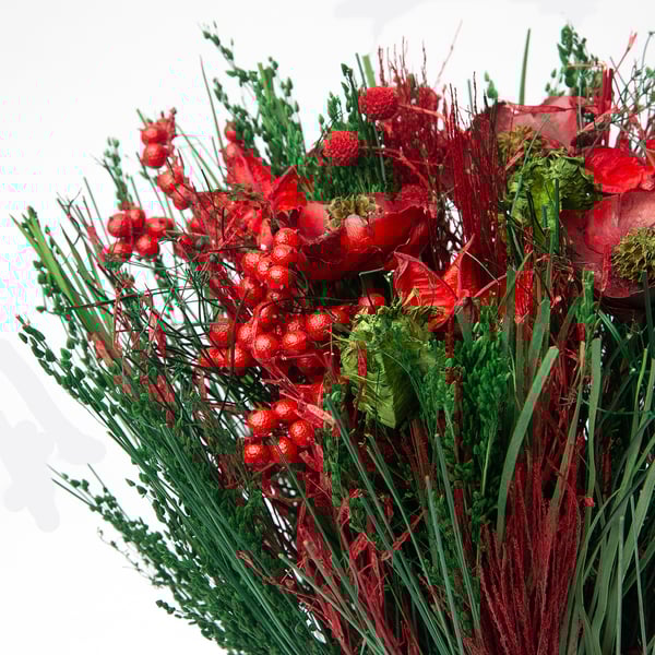 Vibrerande röda torkade blommor och gröna stjälkar arrangerade i en festlig bukett.