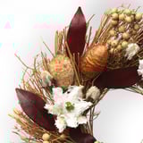 Torkad blommig krans med dämpade toner, texturerade blad och knoppar, arrangerade i en robust, rustik design, som utstrålar naturlig elegans.