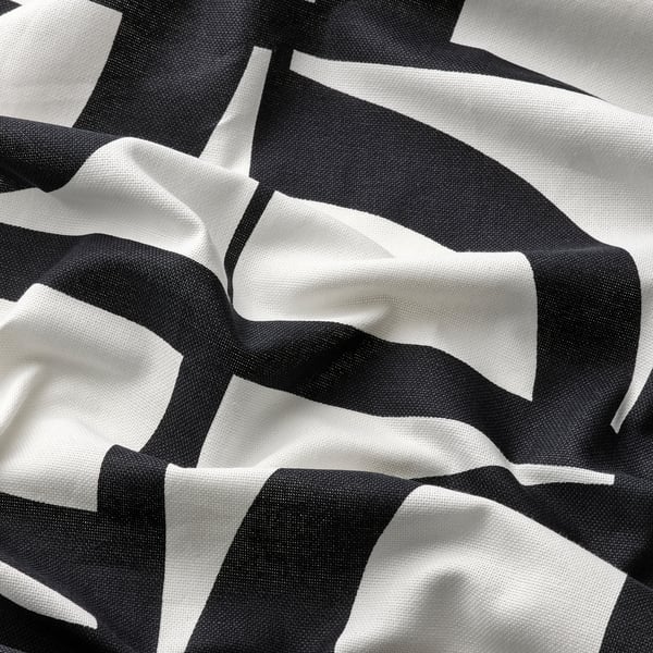 Abstrakt svart och vitt mönster på mjukt, texturerat tyg, skrynkligt för att visa textur och kvalitet.