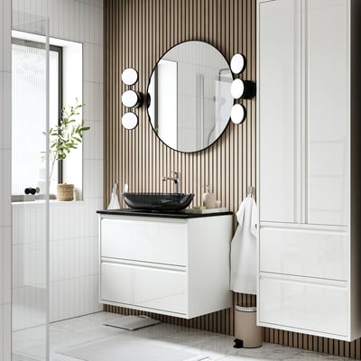 Modern white ÄNGSJÖN vanity with glossy finish, multiple drawers, dark sink, large mirror with lights.