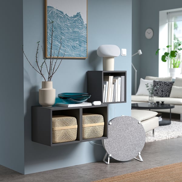 Blue living room with dark shelf, lamp, air monitor, and artwork.